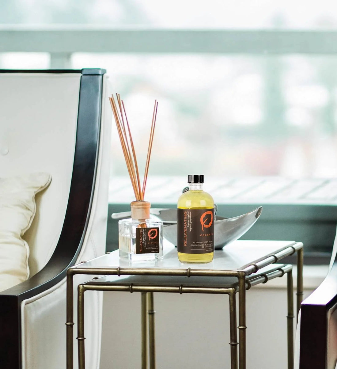 Escents Rejuvenating Reed Diffuser and refill bottle on a side table — Tips for Using Essential Oils With Reed Diffusers